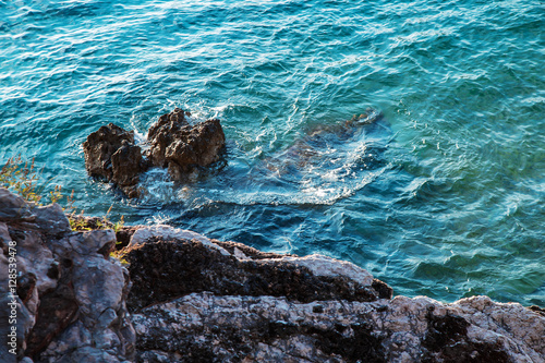 Clear blue sea waves and stone coast