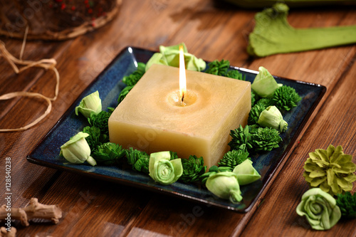 Aromatic rustic candle with green sola flowers  and  potpourri on wodden table photo