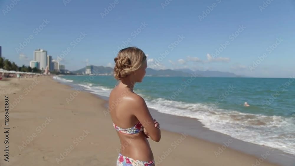 Gorgeous young girl with a beautiful figure posing and walks along the seashore Gorgeous young girl with a beautiful figure posing and walks along the seashore