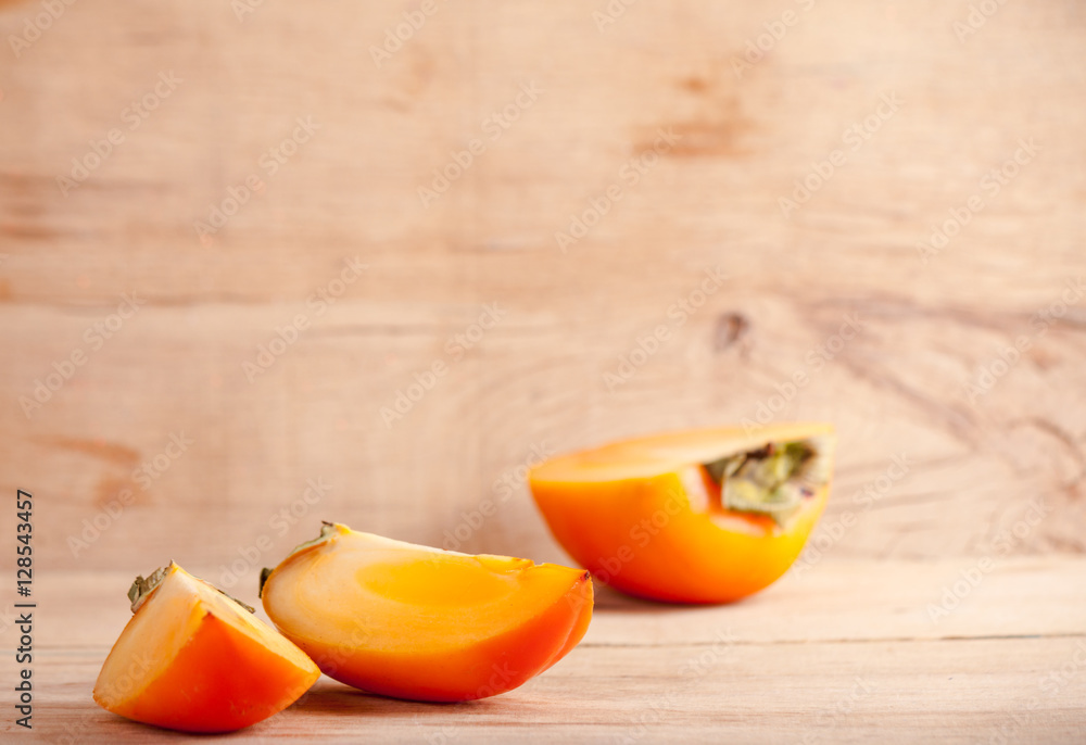 Ripe fresh persimmon on wood board Ripe fresh persimmon on wood board