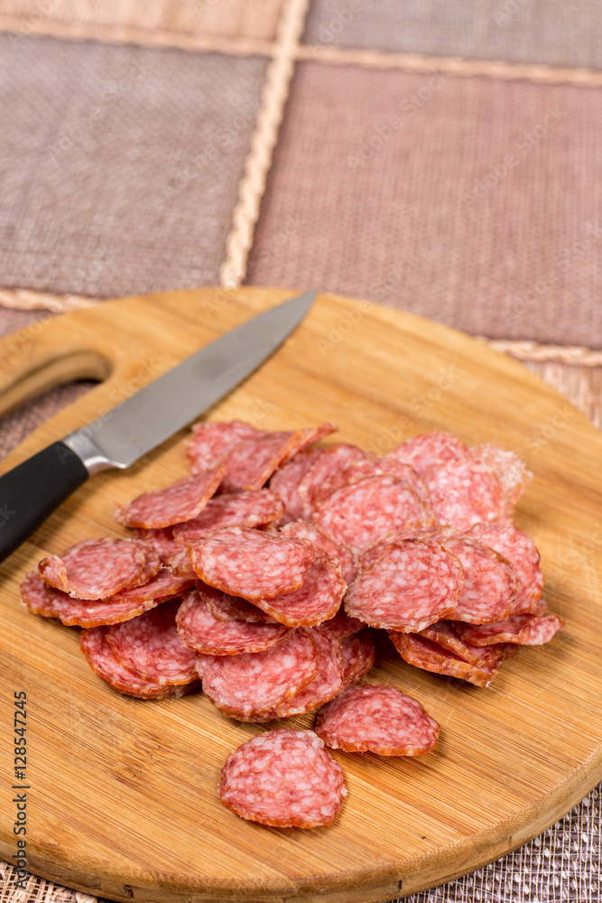 Flat lay overview sliced sausage on the wooden board Flat lay overview sliced sausage on the wooden board