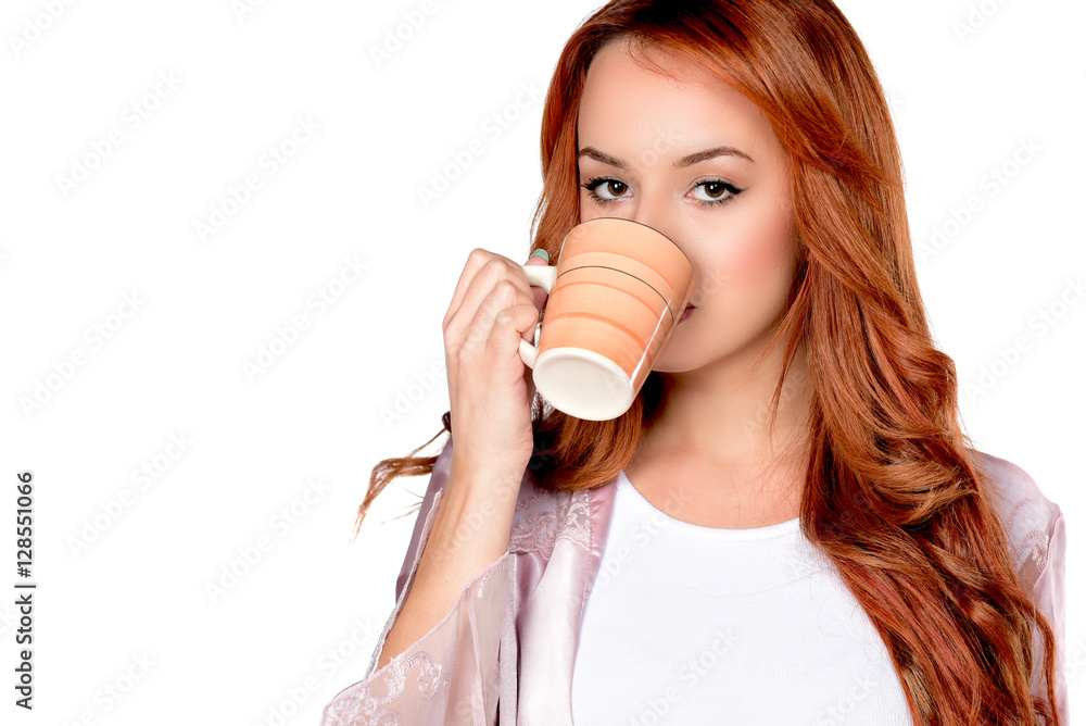 Portrait of lovely redheaded woman siting on big pillow holding drinking cup of coffee, tea, on white background Portrait of lovely redheaded woman siting on big pillow holding drinking cup of coffee, tea, on white background