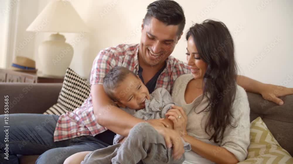 Happy Family Sitting On Sofa At Home Together Happy Family Sitting On Sofa At Home Together