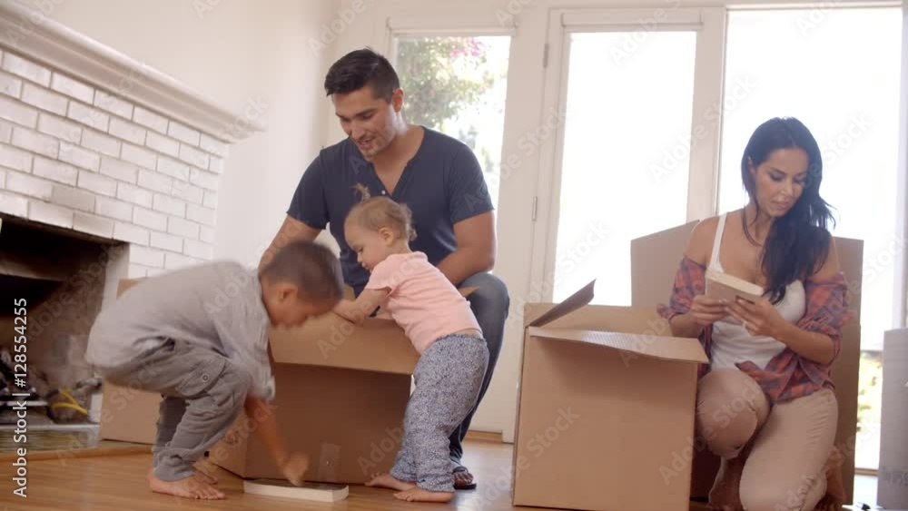 Family Unpacking Boxes In New Home On Moving Day Family Unpacking Boxes In New Home On Moving Day