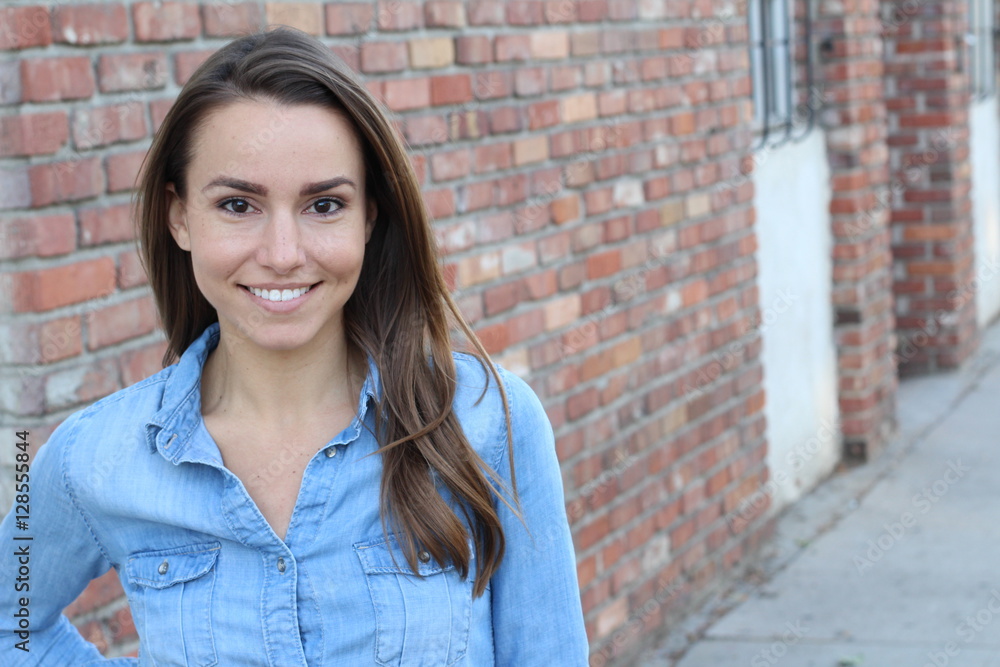 Beautiful casual woman smiling - isolated over a brick wall background with copy space Beautiful casual woman smiling - isolated over a brick wall background with copy space