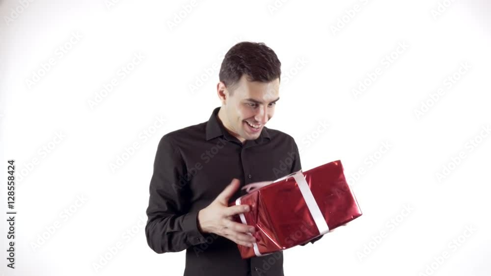 Happy young man gets a gift and opens a box Happy young man gets a gift and opens a box