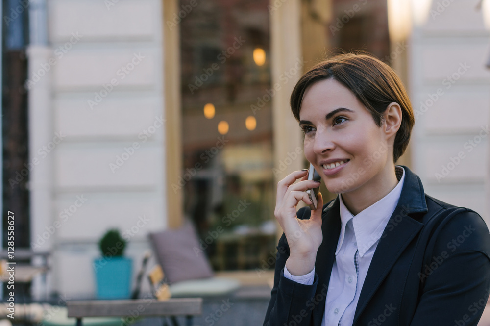 Young business woman talking on mobile phone outside Young business woman talking on mobile phone outside