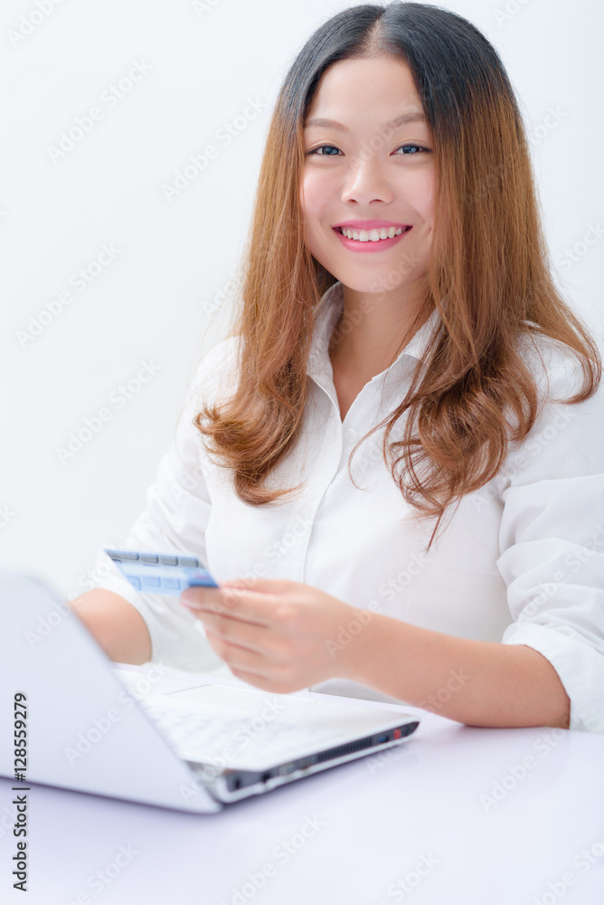 Young woman using credit card paying on laptop. Young woman using credit card paying on laptop.