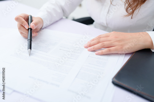 Business woman filling information on document.