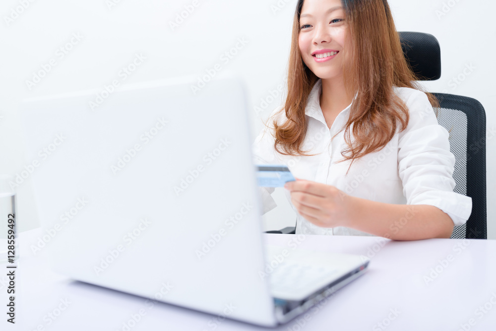 Young woman using credit card paying on laptop. Young woman using credit card paying on laptop.