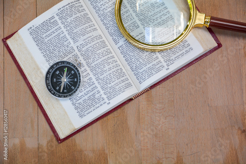 Fotografie bible book and magnifying glass on wood background