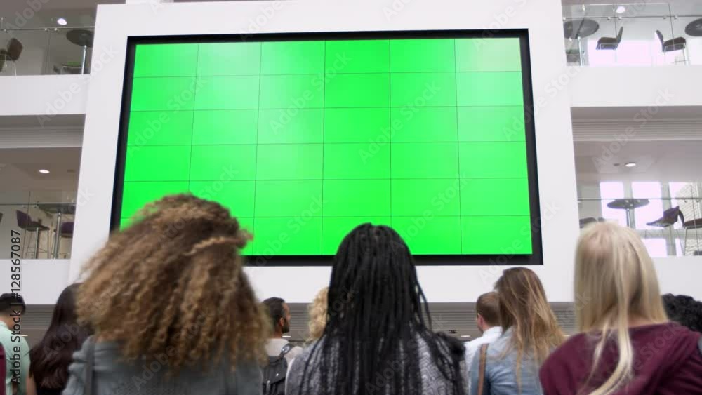 Students under big AV screen in atrium, close up back view, shot on R3D