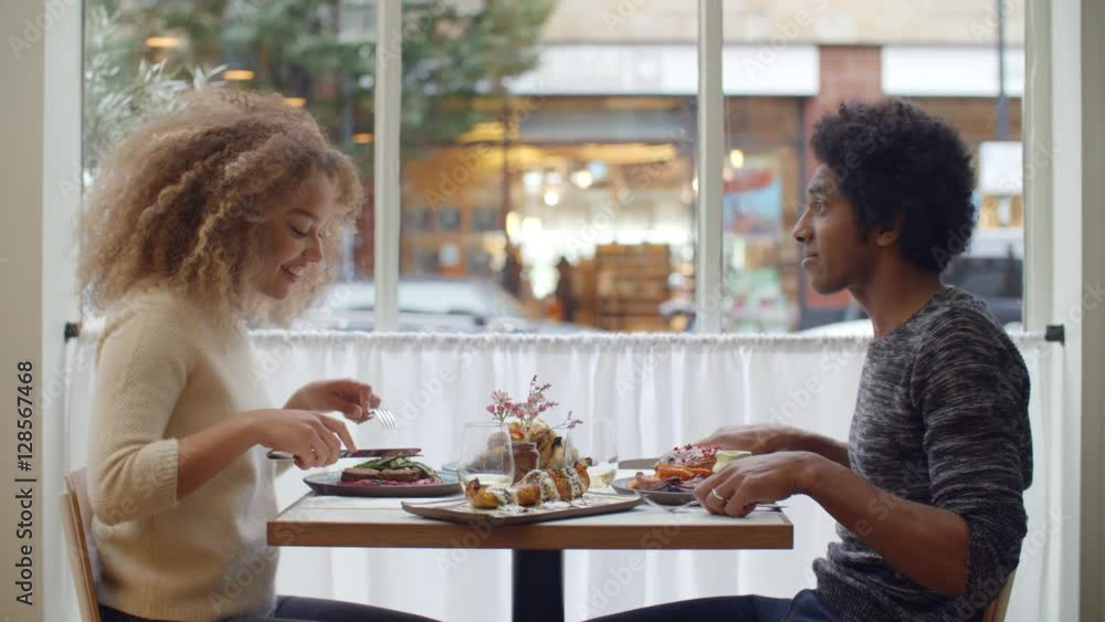 Young Couple Enjoying Meal On Date In City Restaurant Young Couple Enjoying Meal On Date In City Restaurant