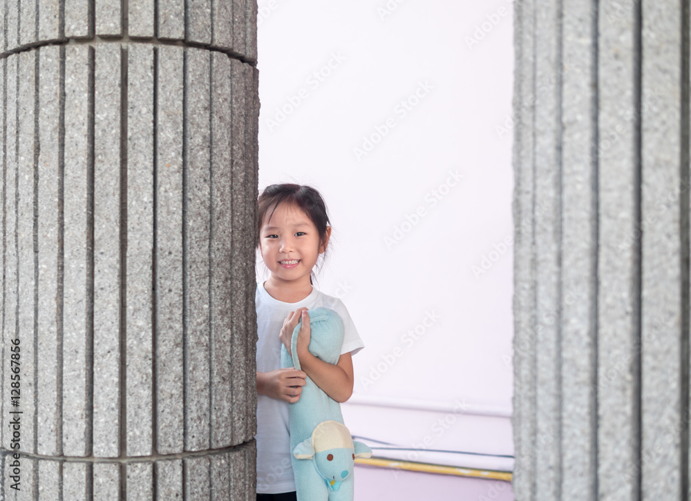 Adorable little girl playing peekaboo, asian child Adorable little girl playing peekaboo, asian child
