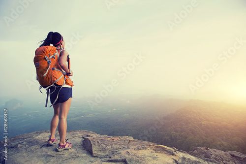 successful woman hiker enjoy the view at mountain peak cliff © lzf