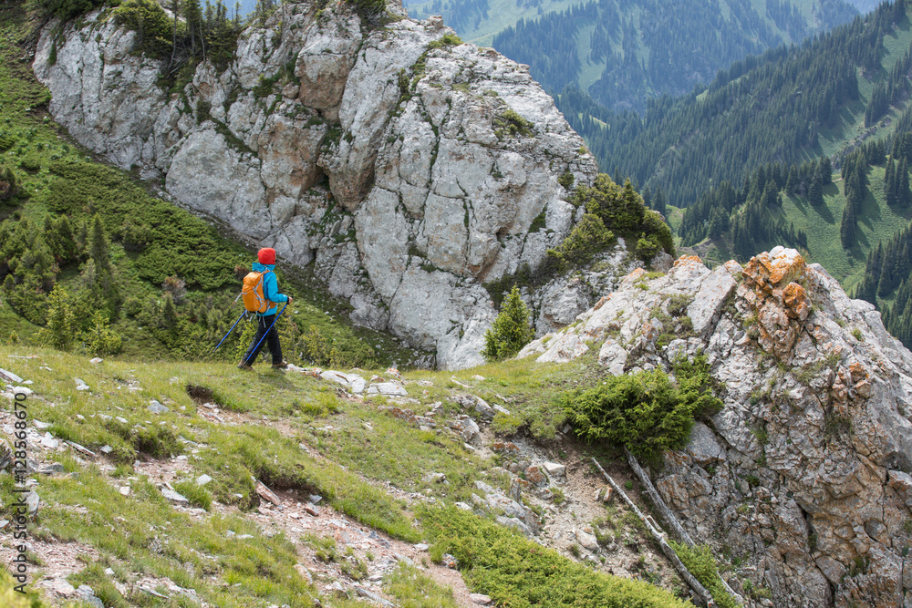 Naklejka premium young woman backpacker hiking on mountain peak