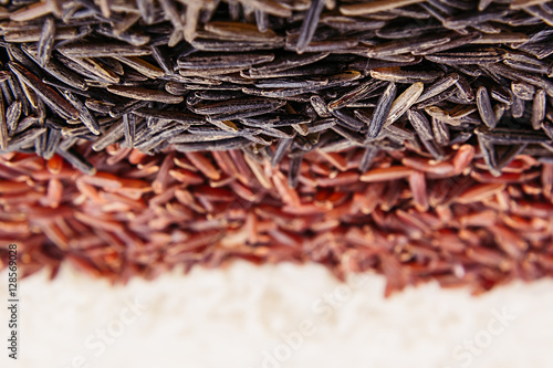 Strips of red, black and white rice close-up. Rice texture background. Macro.