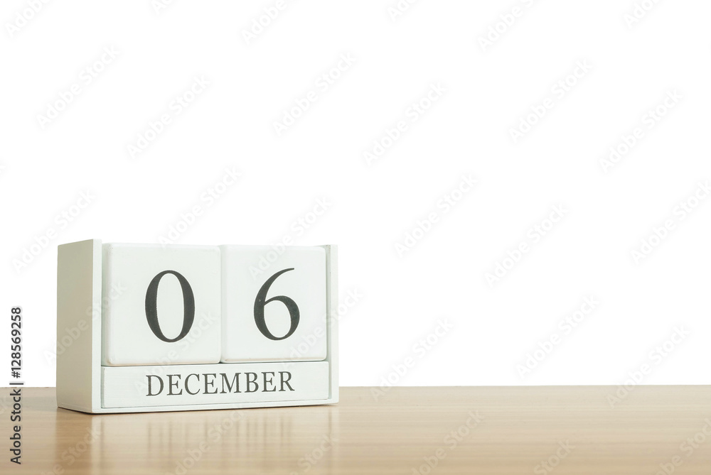 Closeup surface white wooden calendar with black 6 december word on blurred brown wood desk isolated on white background with copy space , selective focus at the calendar Closeup surface white wooden calendar with black 6 december word on blurred brown wood desk isolated on white background with copy space , selective focus at the calendar