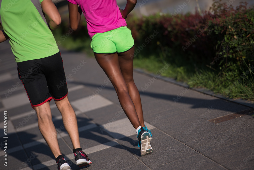 young smiling multiethnic couple jogging in the city