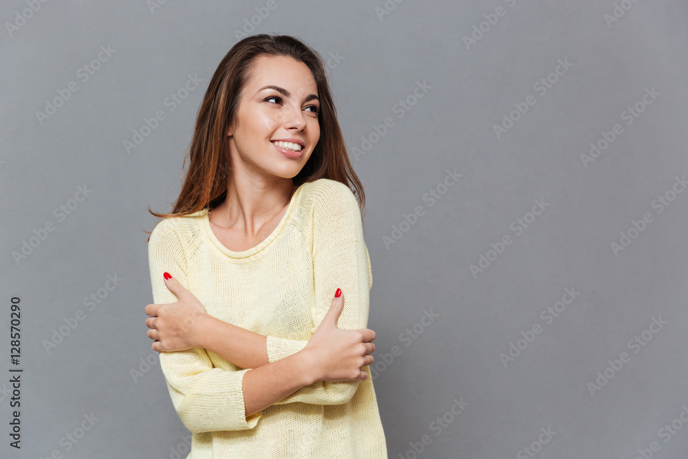 Smiling woman on sweater standong and looking away Smiling woman on sweater standong and looking away