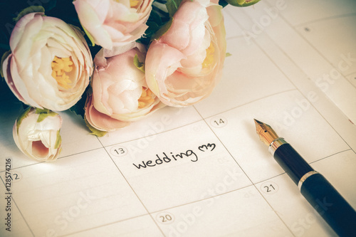 Fotografi word wedding on calendar with sweet flowers and pen  ,love conc