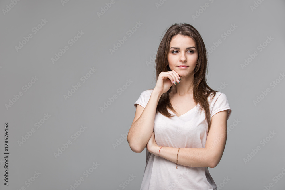 Portrait of beautiful brunette woman with natural make-up, on grey background