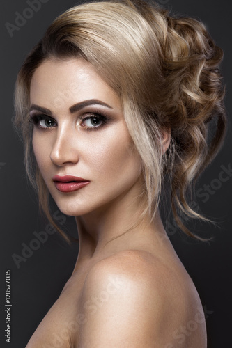 Beautiful blond girl with perfect skin, evening make-up, wedding hairstyle.Beauty face. Picture taken in the studio.