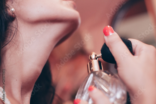 donna sensuale mette il profumo sul collo photo