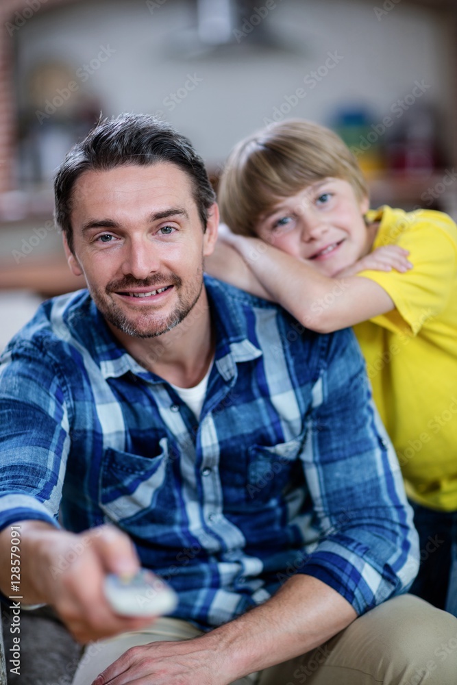 Father and son watching television in living room Father and son watching television in living room