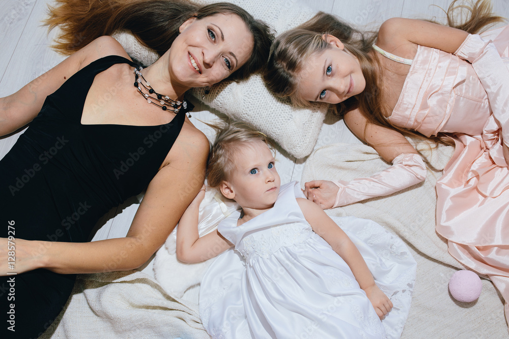 mother and two daughters enjoy life. happy family in festive dresses