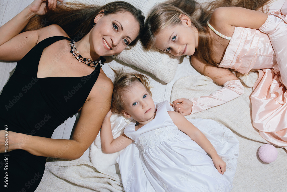 mother and two daughters enjoy life. happy family in festive dresses