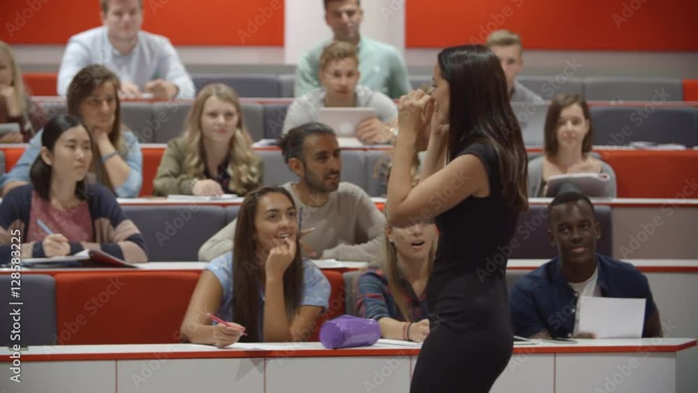 Female teacher and students in university lecture theatre Female teacher and students in university lecture theatre