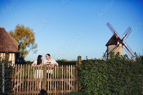 beautiful young woman and man standing near fence
