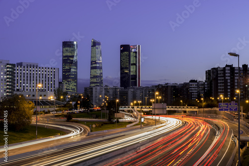 Cuadro en lienzo Atardecer de Madrid con los rascacielos y las luces de la carretera