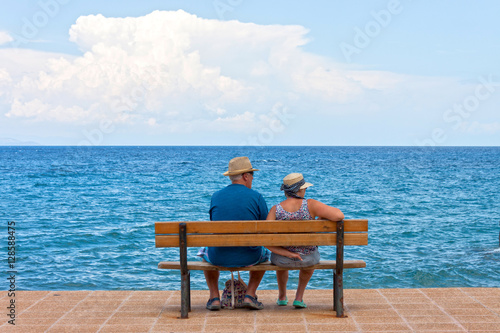 A copy of seniors sitting on a bench at sea shore © xiaoma