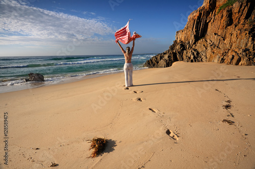 Tablou pe pânză A woman walks along the beach, travel, health and wellbeing