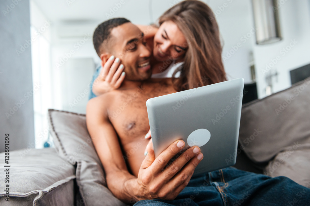 Cheerful young couple using tablet and having fun Cheerful young couple using tablet and having fun