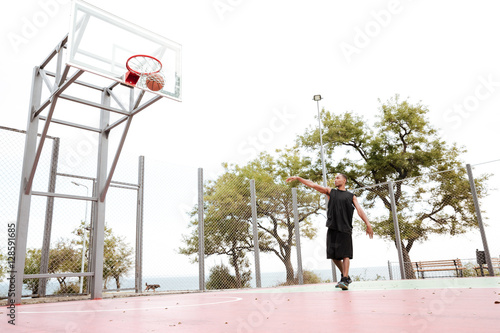 African basketball player practicing in the street background © Drobot Dean