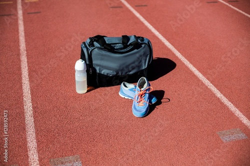 Sports bag, shoes and a water bottle kept on a running track