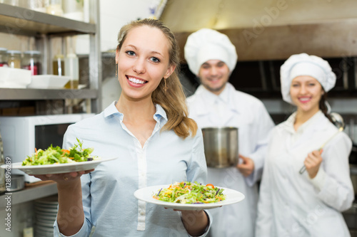 Waitress taking dish from kitchen