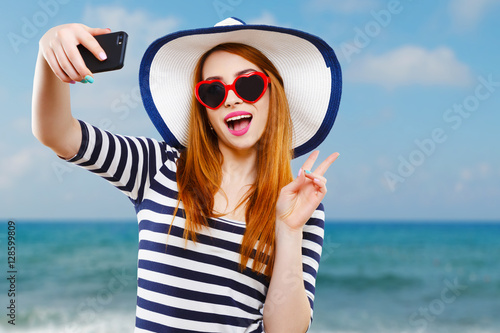 Girl with hat and sunglasses making selfie