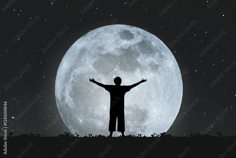 Silhouette a man stretching hands under full moon at night with stars on the sky