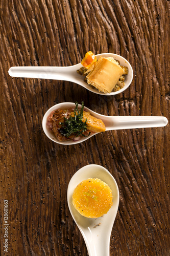 Crunchy with cheese mousse, accompanied with cashew and cashew cashew nuts and Pork mignon with creamy canjiquinha and vinaigrette in a spoon. Taste gastronomy fingerfood photo