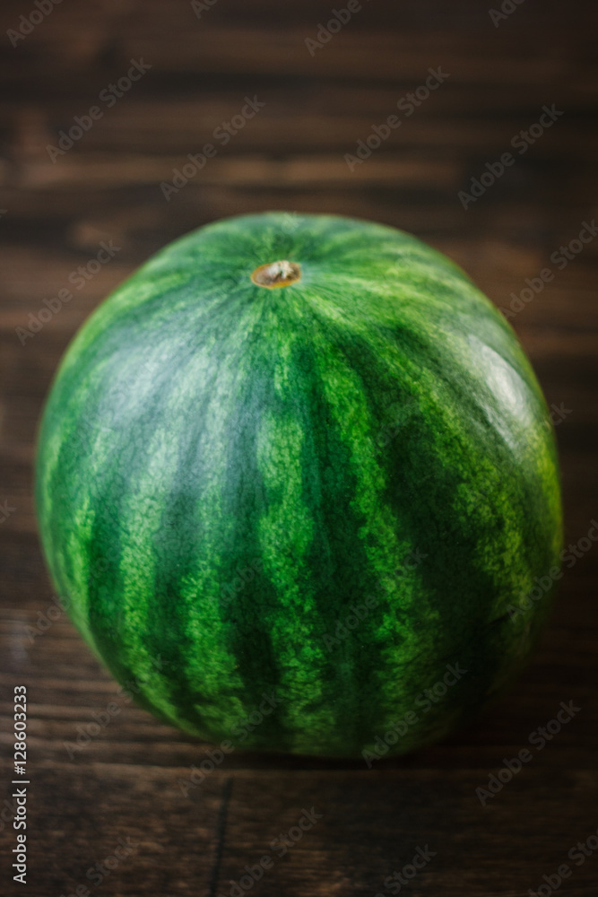 Watermelon. Whole undivided fresh green watermelon on brown wooden board Watermelon. Whole undivided fresh green watermelon on brown wooden board