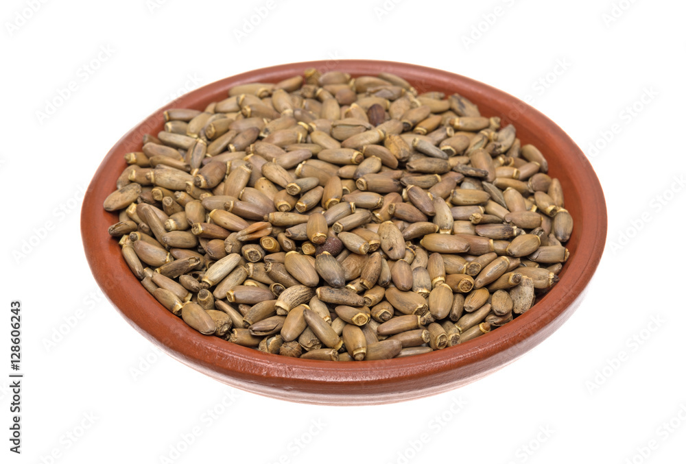 Organic milk thistle seeds in a small bowl isolated on a white background.