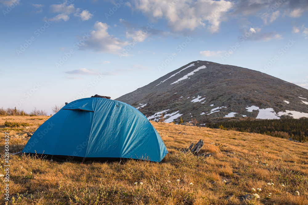 Camping tent near high moutain in the evening sunset time, Ural, Russia