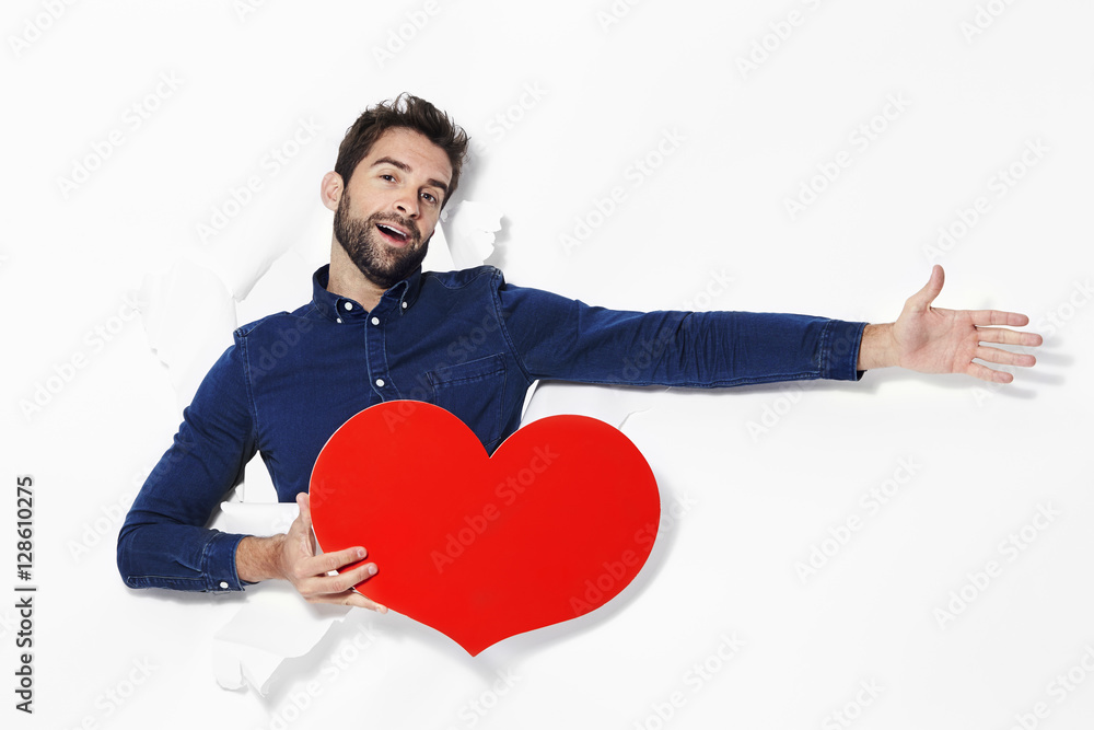 Man declaring love with heart in studio Man declaring love with heart in studio