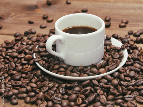Black coffee in white mug and grains