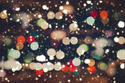 Christmas Lights blurred bokeh with snowfall background from night party for your design, vintage or retro color effect
