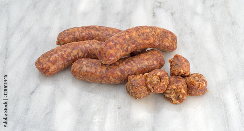 Bratwurst chunks and links on a gray marble cutting board. Bratwurst chunks and links on a gray marble cutting board.